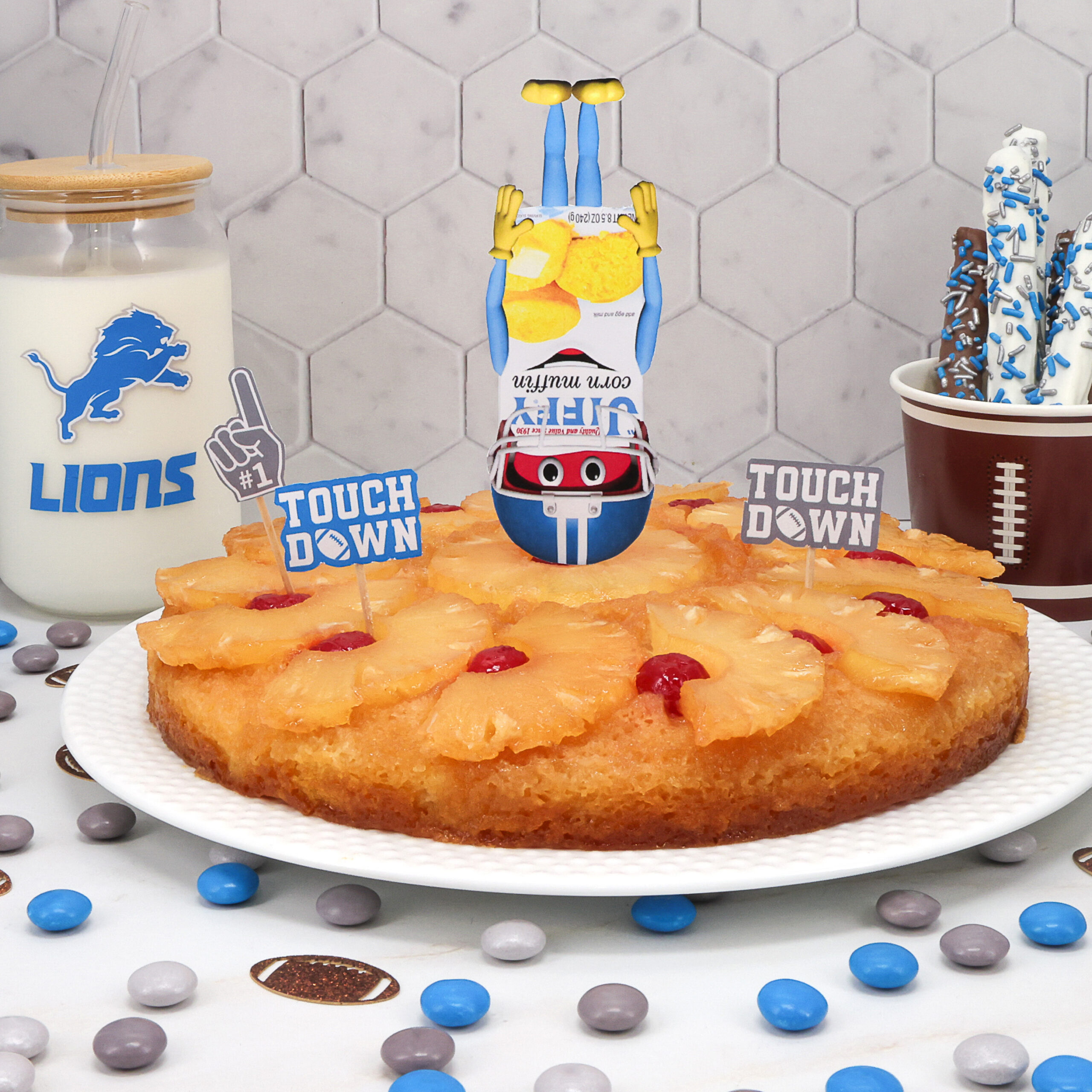 Playful dessert scene with orange jelly donuts on a white plate, a cartoon juice-box figure doing a handstand in the center, and decorated treats on both sides.